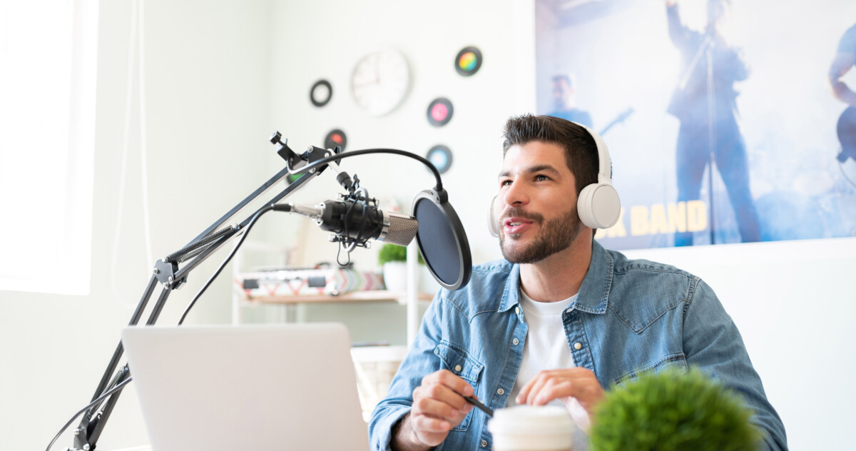 Man with headphones on singing into a studio microphone