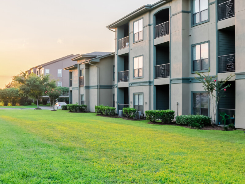 Apartment buildings overlooking a sunset and green field