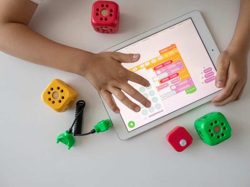 Child Playing With Tablet and Toys